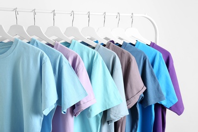 Photo of Men's clothes hanging on wardrobe rack against white background