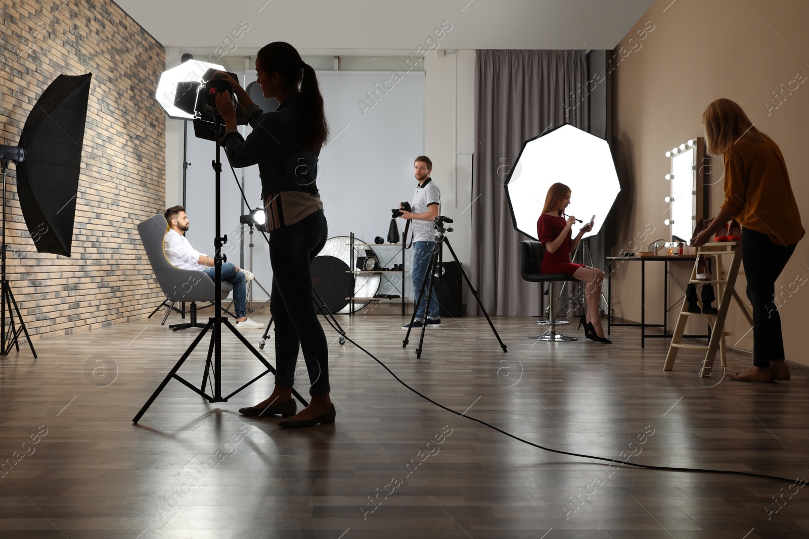 Photo of Photo studio with professional equipment and team of workers