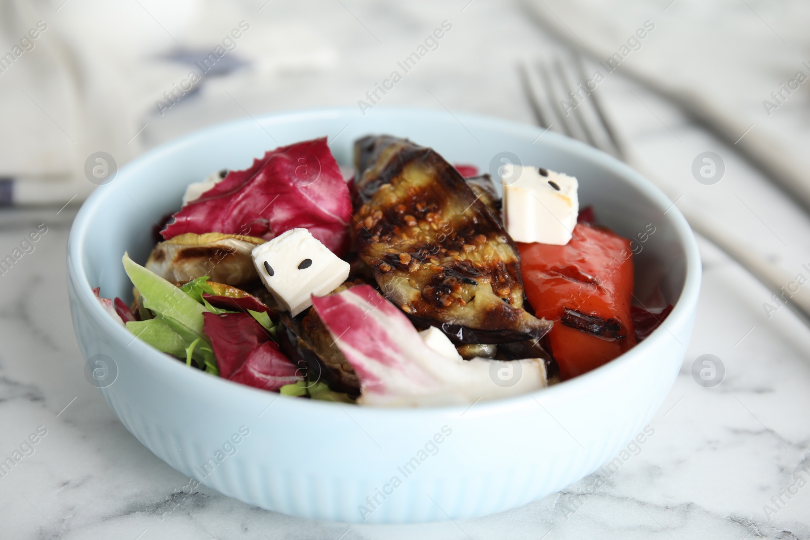 Photo of Delicious salad with roasted eggplant, feta cheese and chia seeds served on white marble table