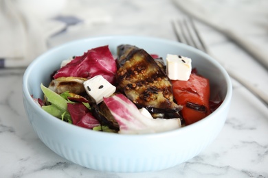 Photo of Delicious salad with roasted eggplant, feta cheese and chia seeds served on white marble table