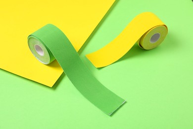 Photo of Bright kinesio tape in rolls on color background