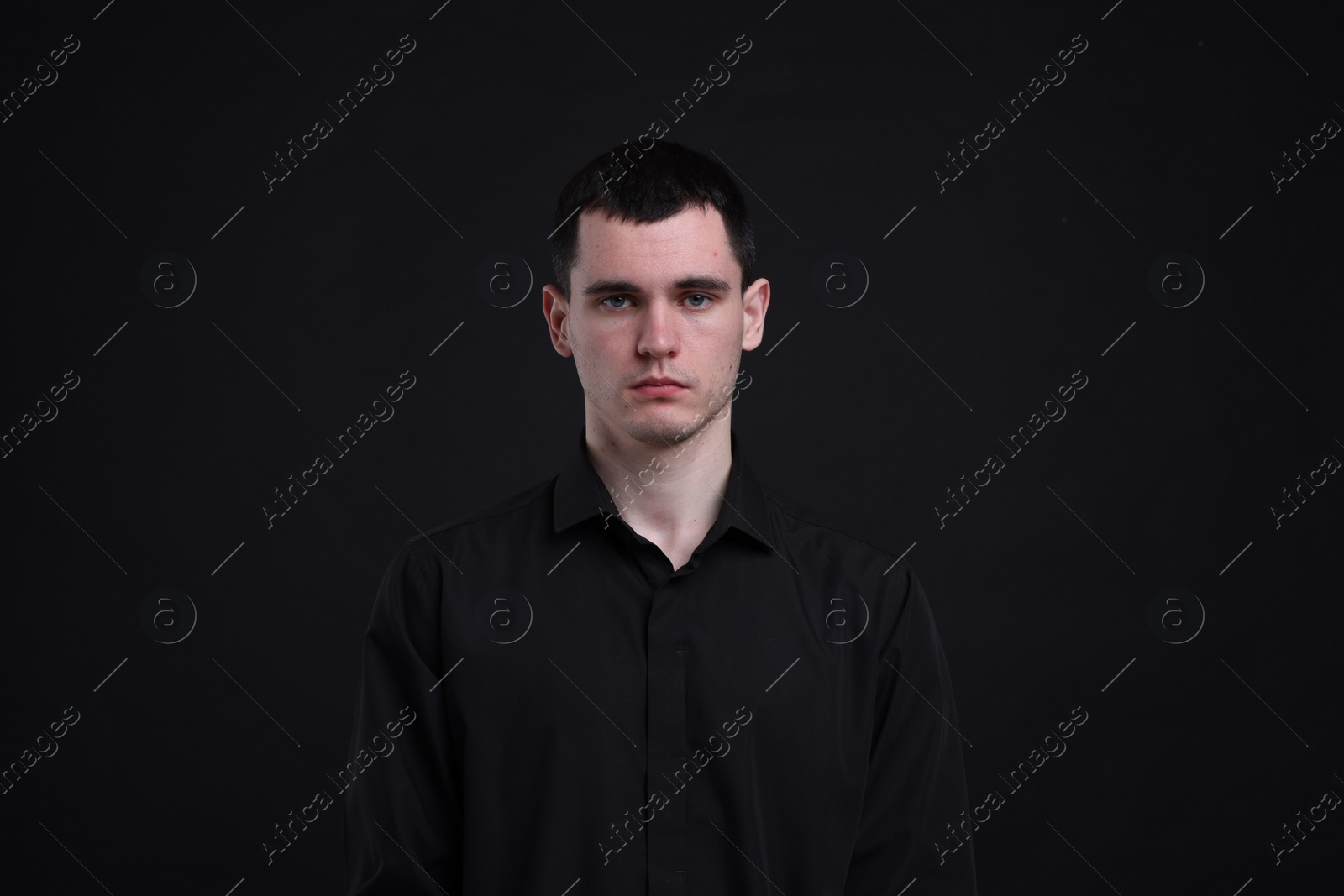 Photo of Portrait of sad man on black background