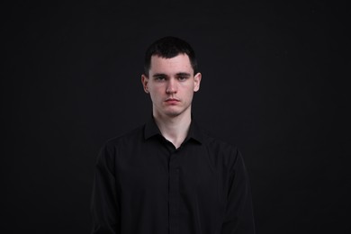 Photo of Portrait of sad man on black background