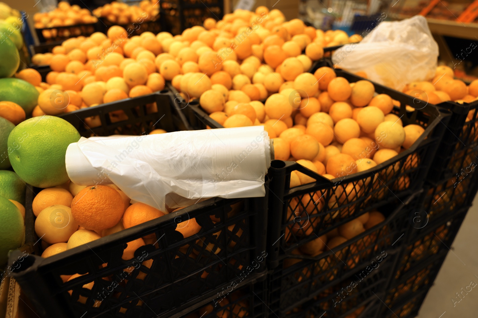 Photo of Plastic bags on crates with fruits in supermarket