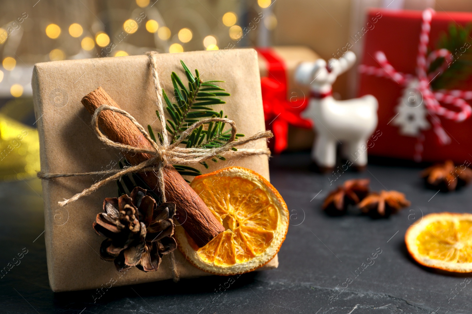 Photo of Beautiful gift box with Christmas decorations on black table, closeup. Space for text