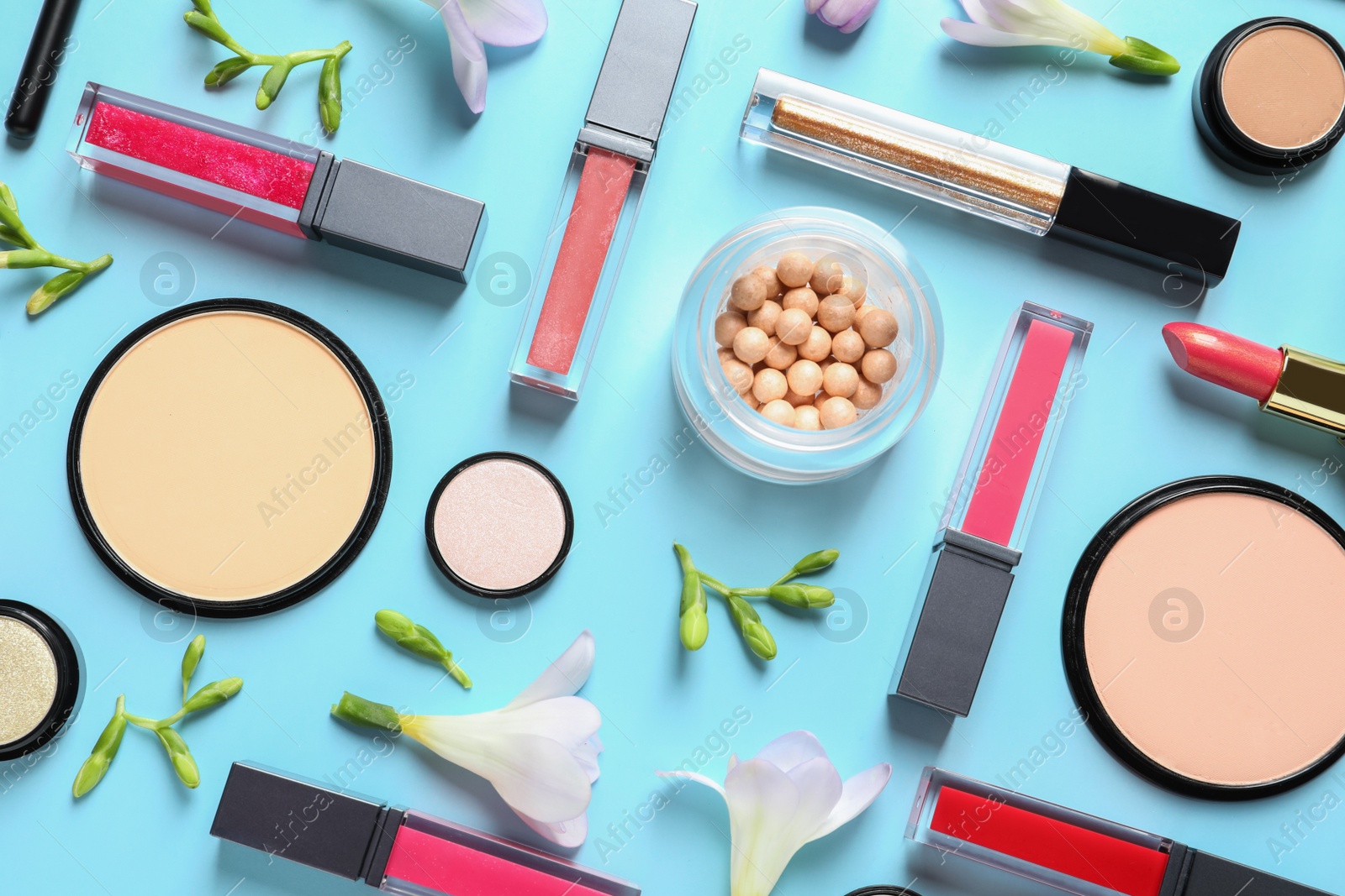 Photo of Makeup products and flowers on color background, flat lay