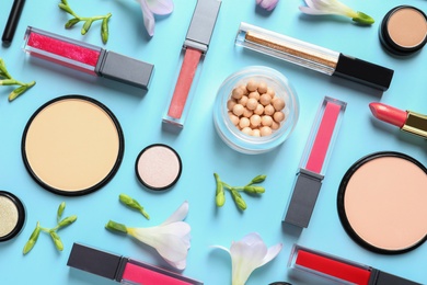 Photo of Makeup products and flowers on color background, flat lay