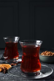 Photo of Glasses of traditional Turkish tea on grey textured table