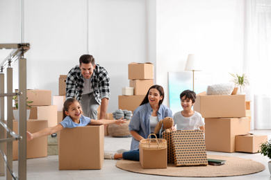 Happy family having fun while unpacking moving boxes at their new home