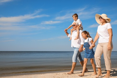 Cute little children with grandparents spending time together on sea beach