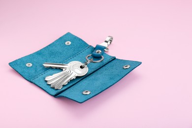Photo of Stylish leather holder with keys on pink background