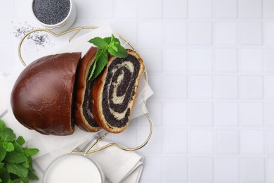 Photo of Slices of poppy seed roll served on white tiled table, flat lay with space for text. Tasty cake