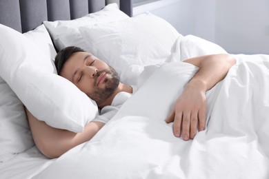 Photo of Handsome man sleeping in soft bed at home