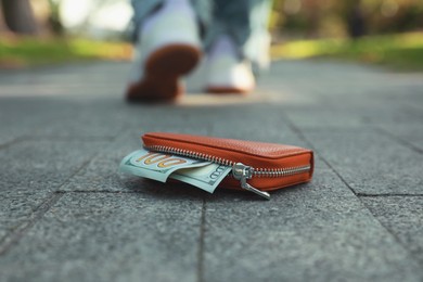 Photo of Woman lost her purse on pavement outdoors, selective focus