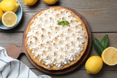 Photo of Flat lay composition with delicious lemon meringue pie on wooden table