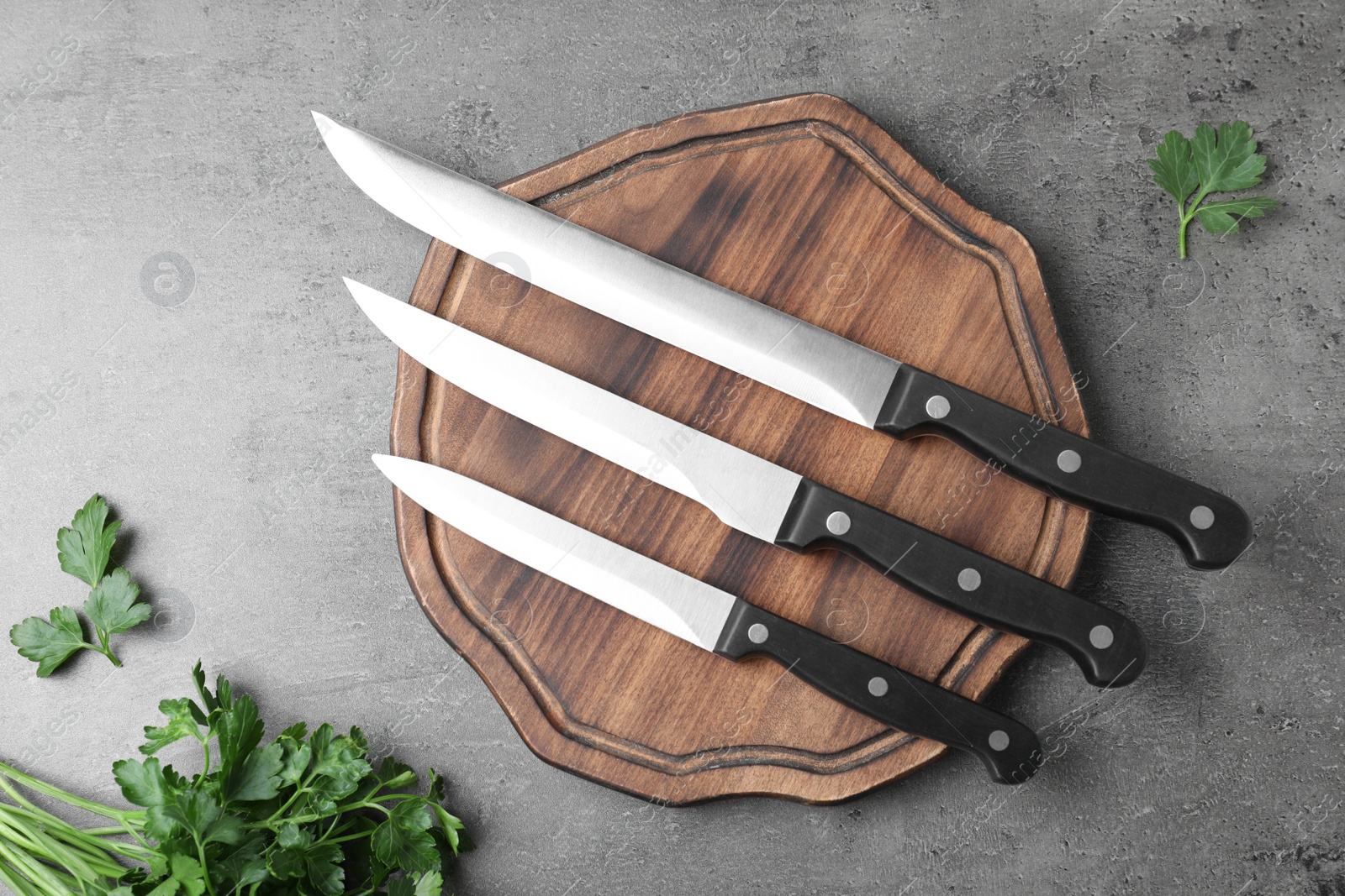 Photo of Flat lay composition with cutting board and knives on grey background