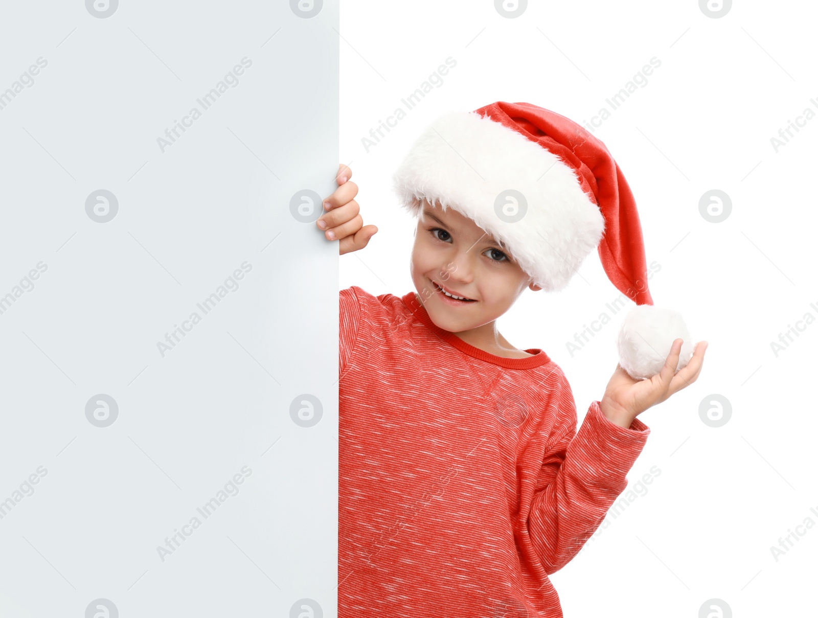 Photo of Cute little child wearing Santa hat on white background. Christmas holiday