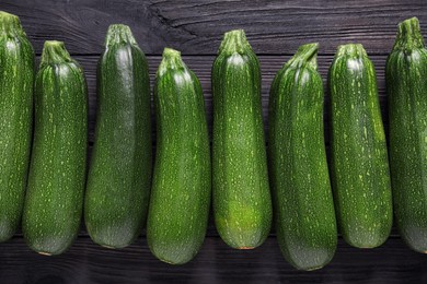 Photo of Raw ripe zucchinis on black wooden table, flat lay