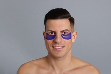 Photo of Man with blue under eye patches on grey background