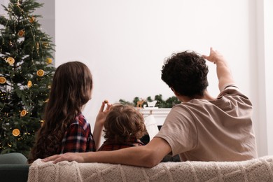 Family watching movie via video projector at home, back view