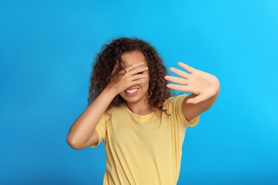 Photo of Young African-American woman being blinded on blue background