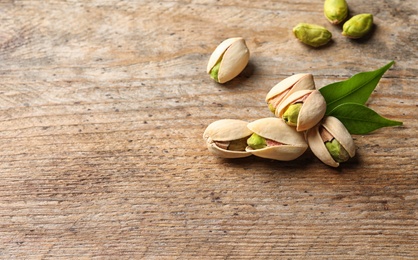 Organic pistachio nuts on wooden table. Space for text