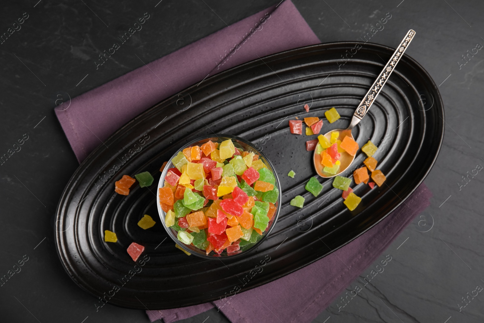 Photo of Mix of delicious candied fruits on black table, flat lay