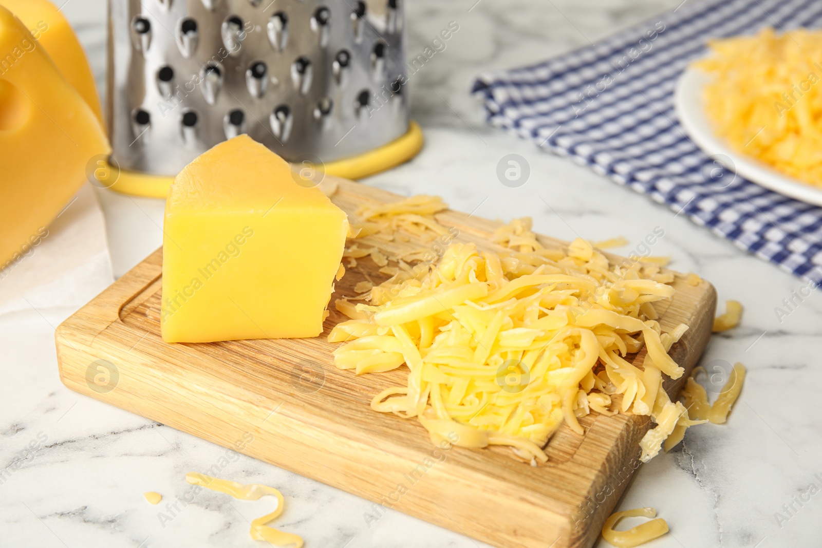 Photo of Delicious grated cheese on white marble table