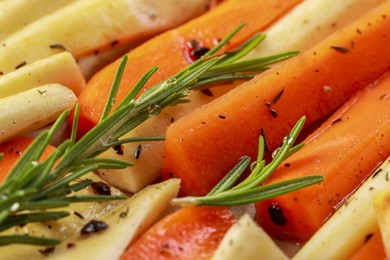 Photo of Slices of parsnip and carrot with rosemary, closeup