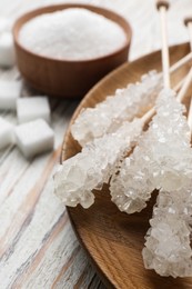 Photo of Different types of sugar on white wooden table, closeup