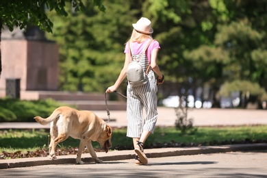 Photo of Young woman and her dog spending time together outdoors. Pet care