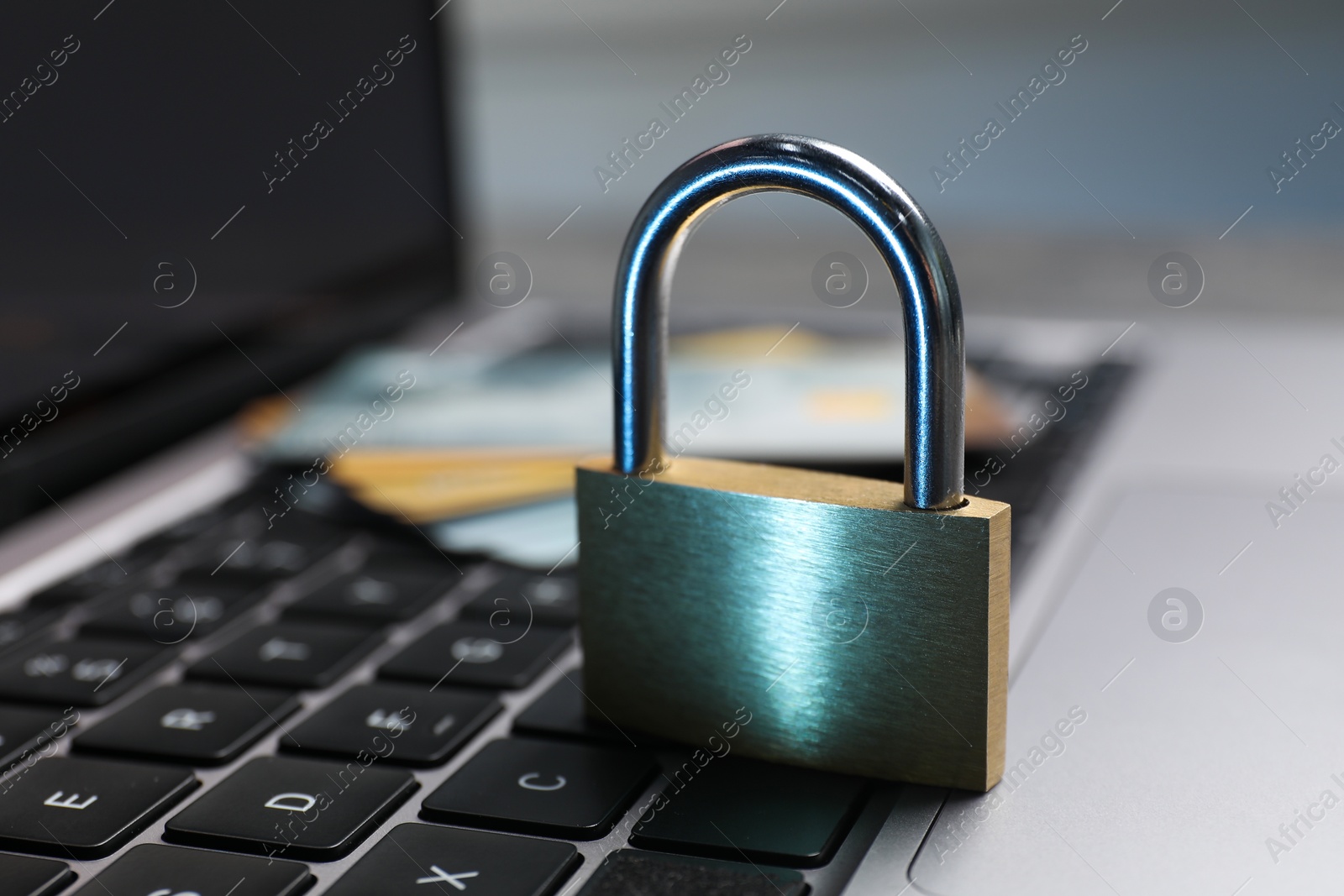 Photo of Cyber security. Metal padlock on laptop, closeup