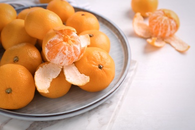 Photo of Fresh tangerines on white table. Citrus fruit