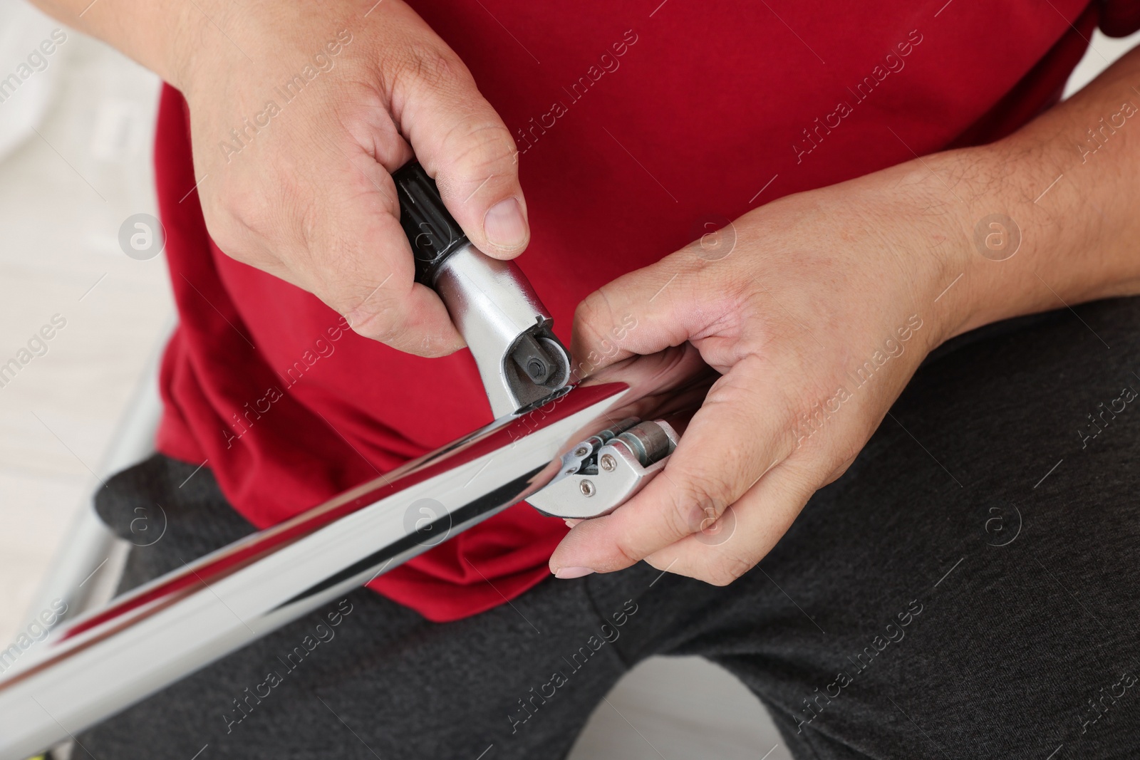 Photo of Worker installing new metal pipes indoors, closeup