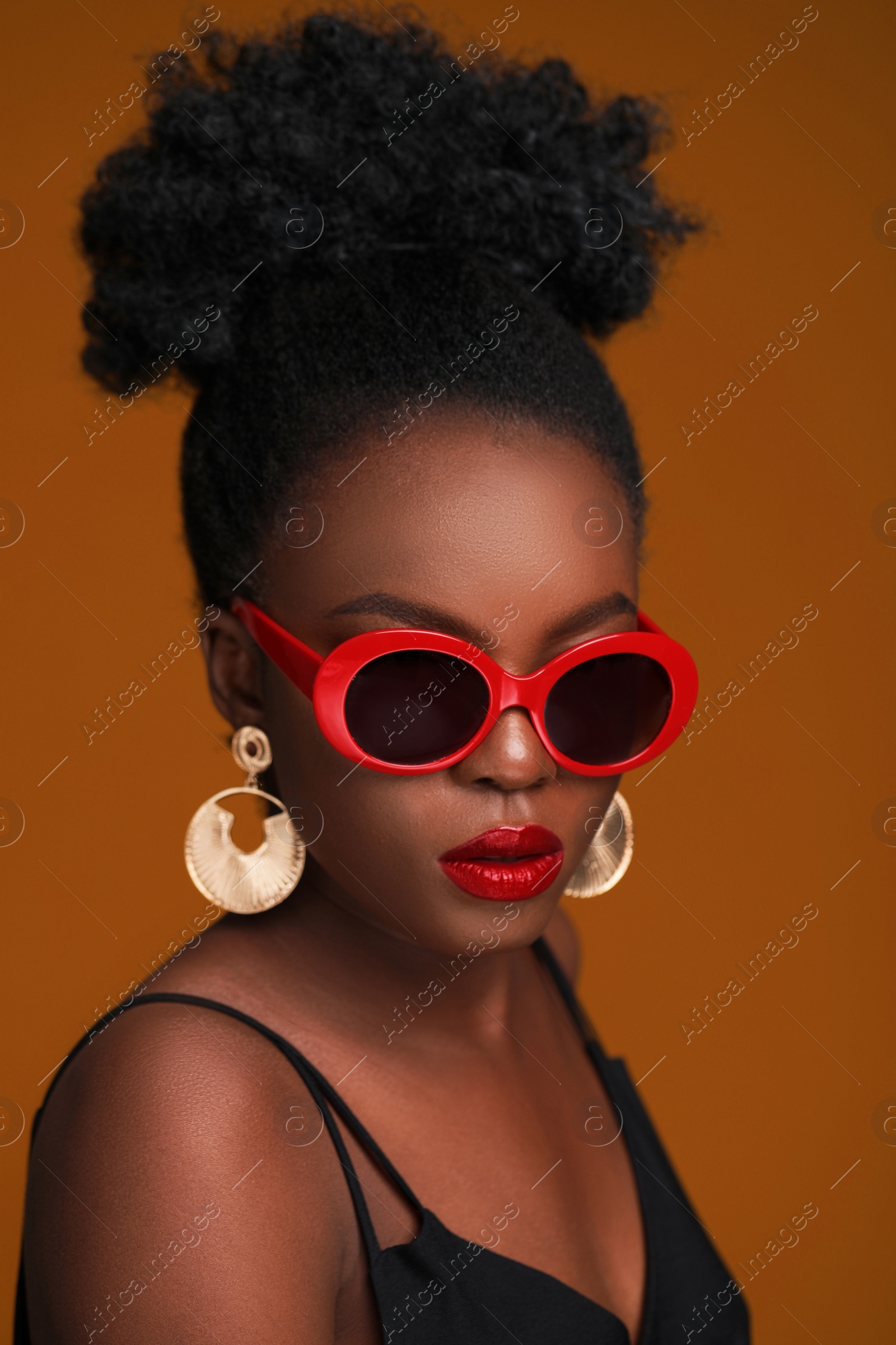 Photo of Fashionable portrait of beautiful woman with stylish sunglasses on light brown background