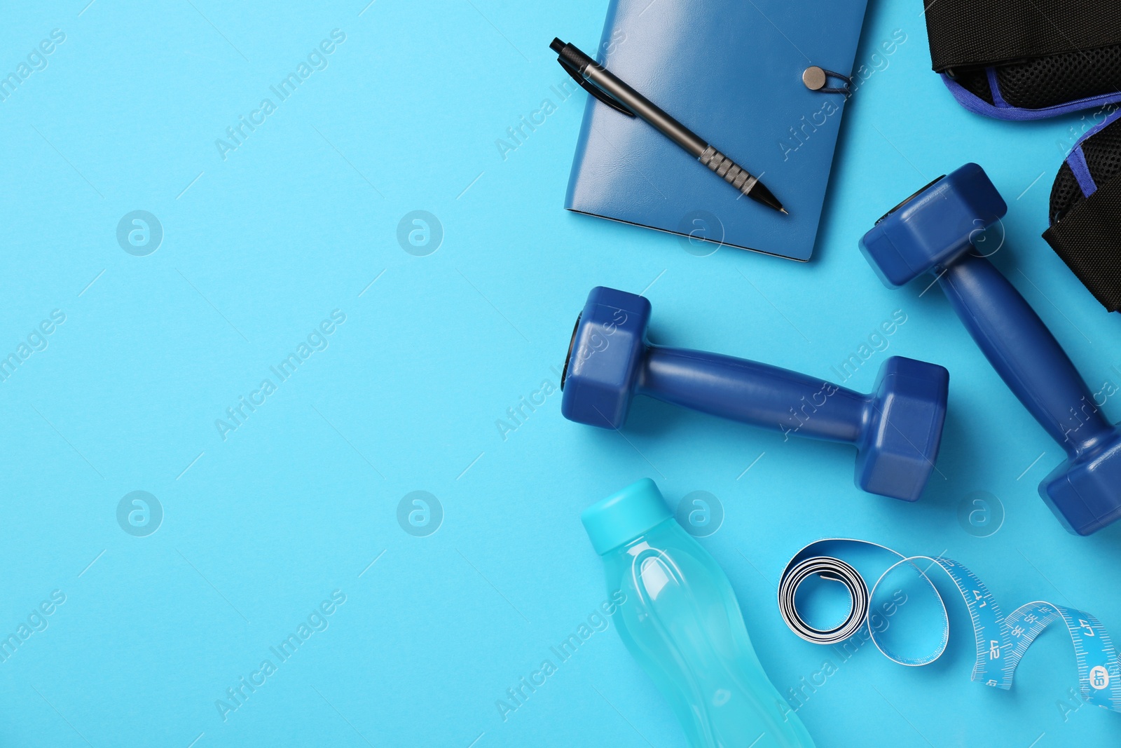 Photo of Flat lay composition with dumbbells on light blue background, space for text