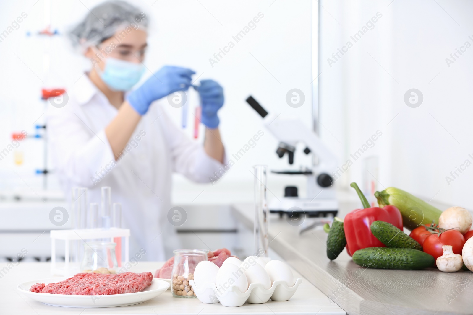 Photo of Different food on table and scientist proceeding quality control in laboratory