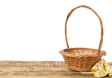 Wicker basket and towel on wooden table against white background, space for text. Easter item