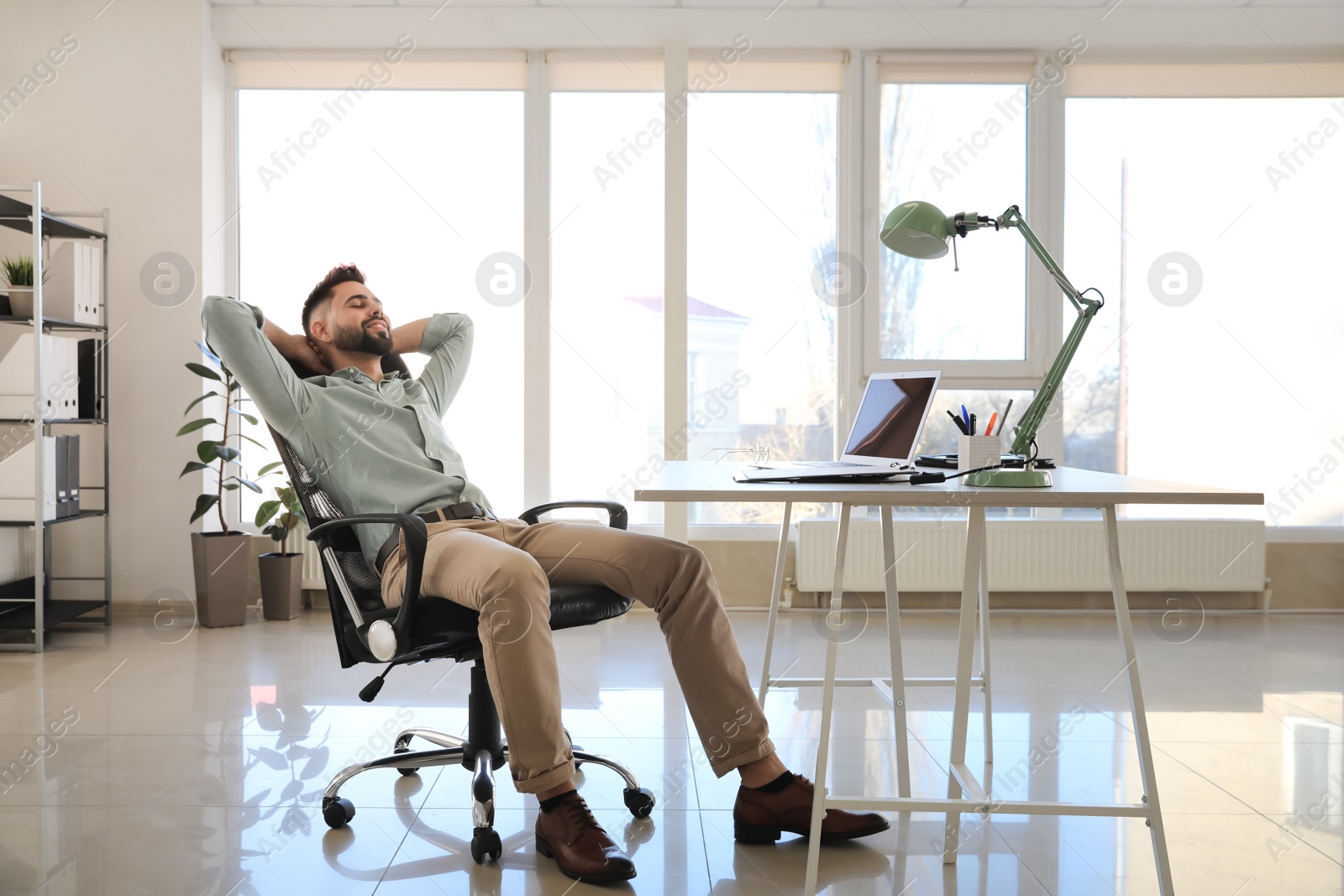 Photo of Businessman relaxing in office chair at workplace