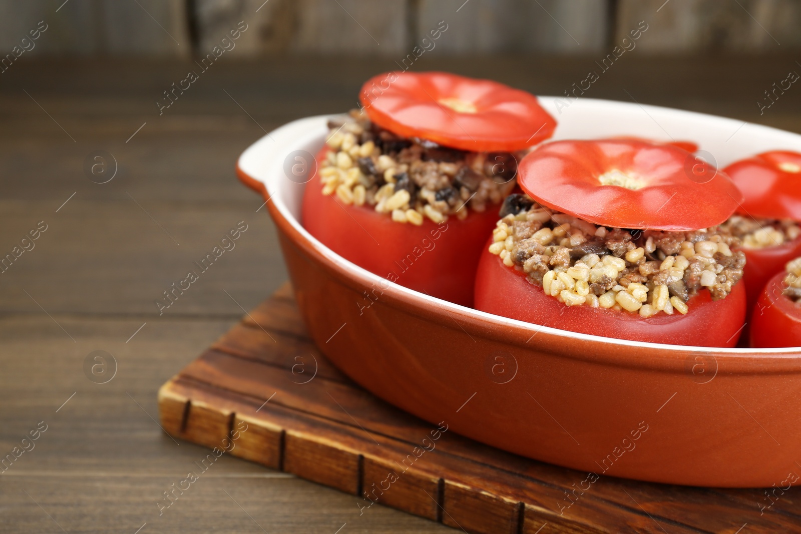Photo of Delicious stuffed tomatoes with minced beef, bulgur and mushrooms in baking dish, closeup. Space for text