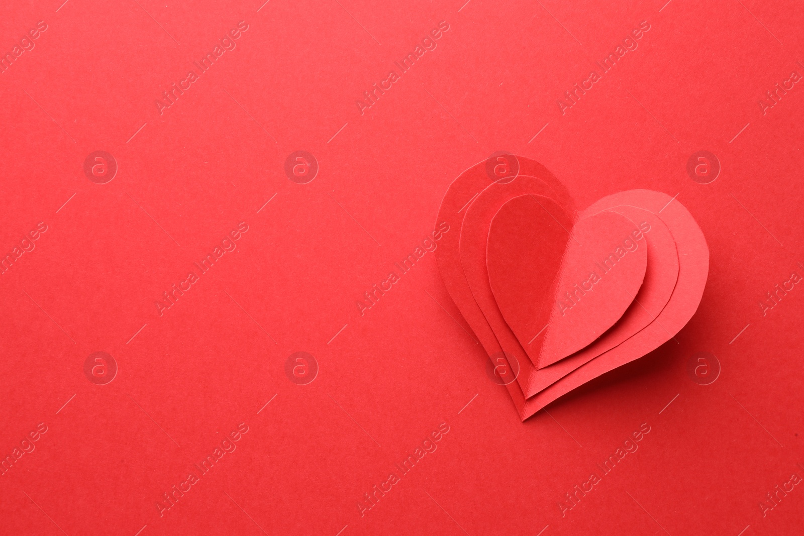 Photo of Paper hearts on red background, top view. Space for text