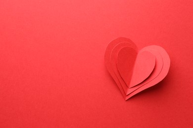 Paper hearts on red background, top view. Space for text