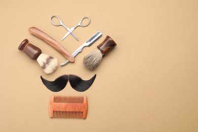 Photo of Artificial moustache and barber tools on beige background, flat lay. Space for text