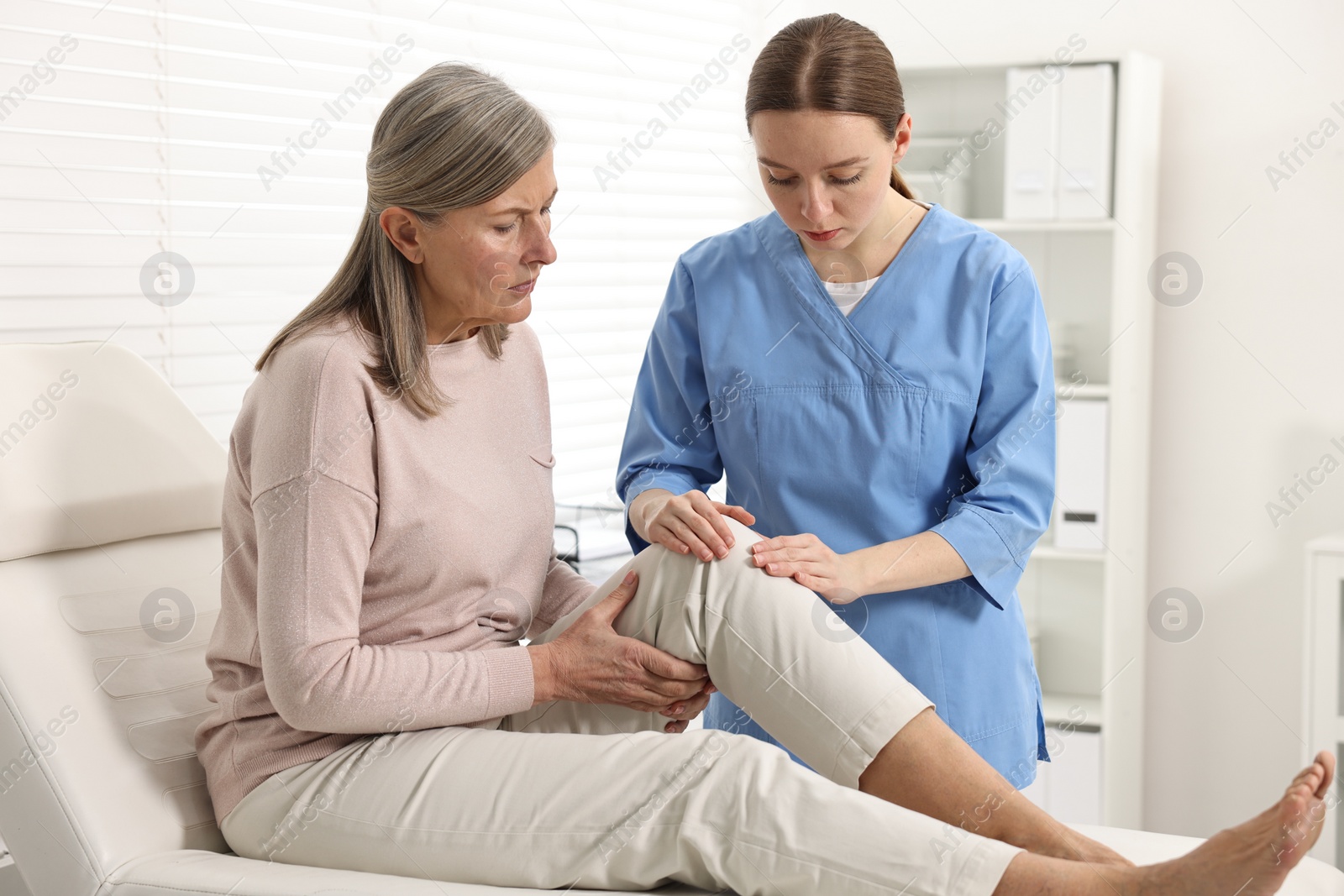 Photo of Arthritis symptoms. Doctor examining patient with knee pain in hospital