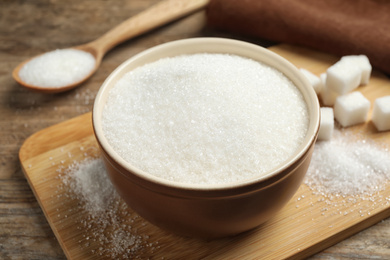 Granulated sugar in bowl on wooden table