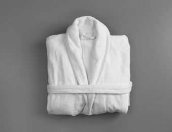 Photo of Clean folded bathrobe on grey background, top view