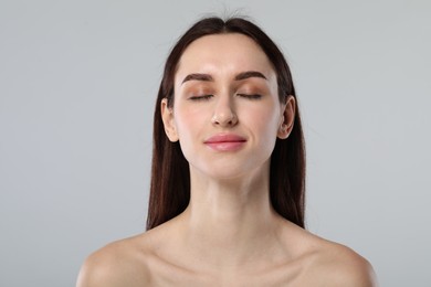 Portrait of beautiful young woman on light grey background