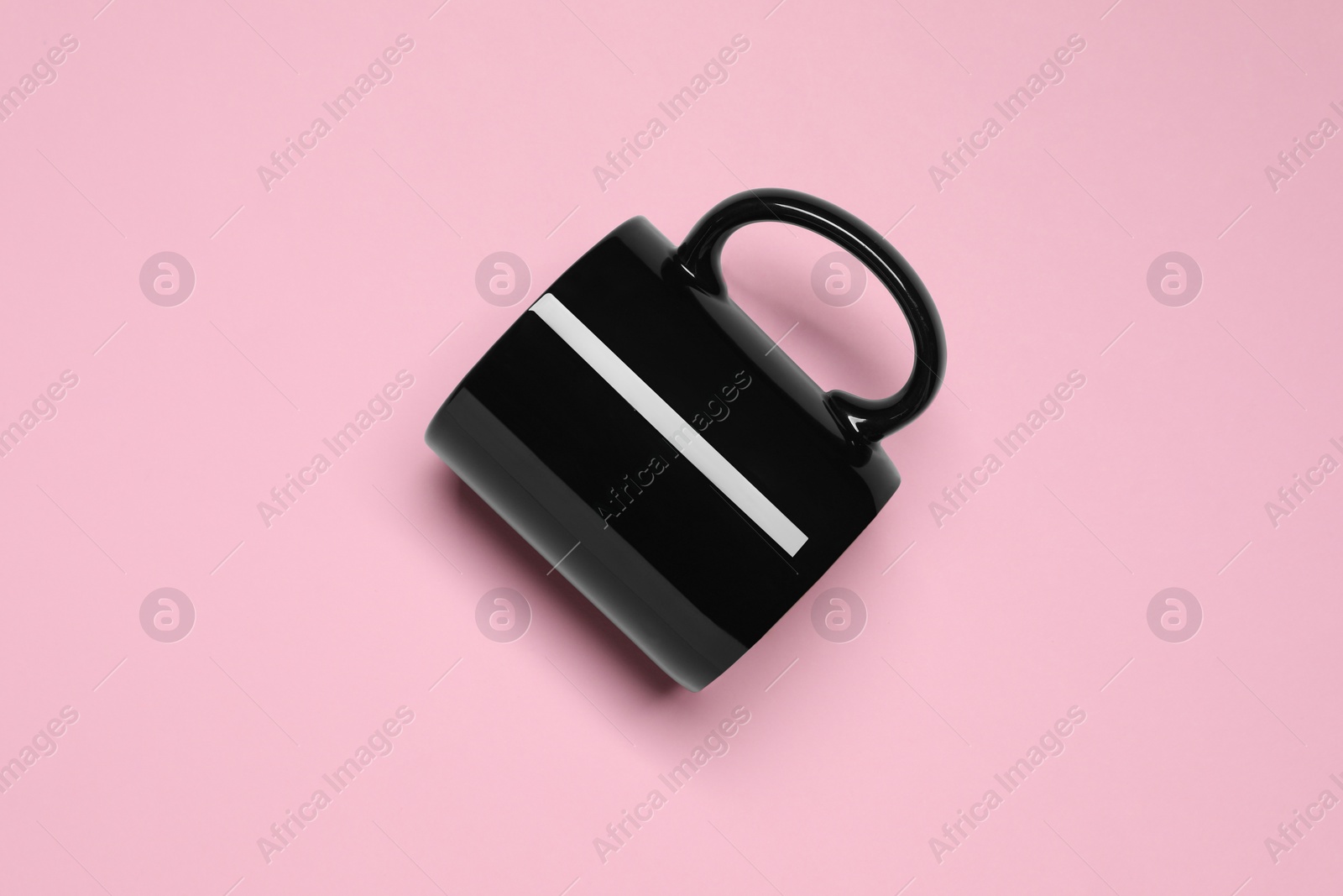 Black ceramic mug on pink background, top view Photo of Black ceramic mug on pink background, top view