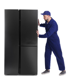 Professional worker carrying refrigerator on white background