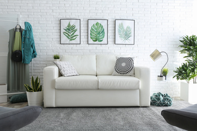 Photo of Comfortable white sofa in modern room. Interior design